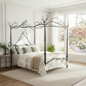A canopy bed with a dark branch-and-bud metal frame, styled in a bright, modern bedroom with white walls, a beige rug, and large windows.