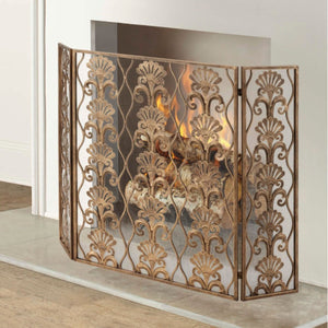 Decorative fireplace screen with floral patterns in a room with a white fireplace.