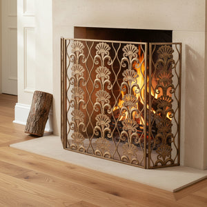 Decorative fireplace screen with floral patterns in a room with a white fireplace.