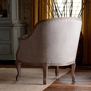 Vintage-style armchair in a room with wooden floor and decorative elements.