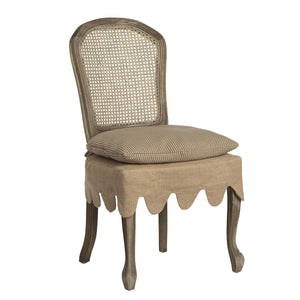 Beige chair with wicker back and scalloped skirt on a white background