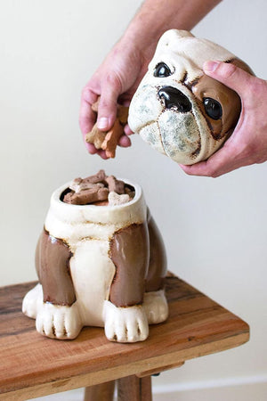 Hand lifting the head lid off the ceramic bulldog treat canister