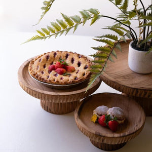 Three carved wood pedestal stands in graduated sizes