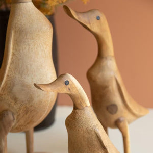 Detail of hand-carved duck figures in natural brown wood