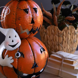 Close-up of white ghost peeking beside bottom jack-o-lantern