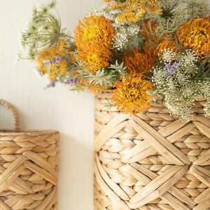 Close-up of woven wall basket with yellow dried florals