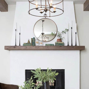 Black cast iron candlesticks styled on a white fireplace mantel