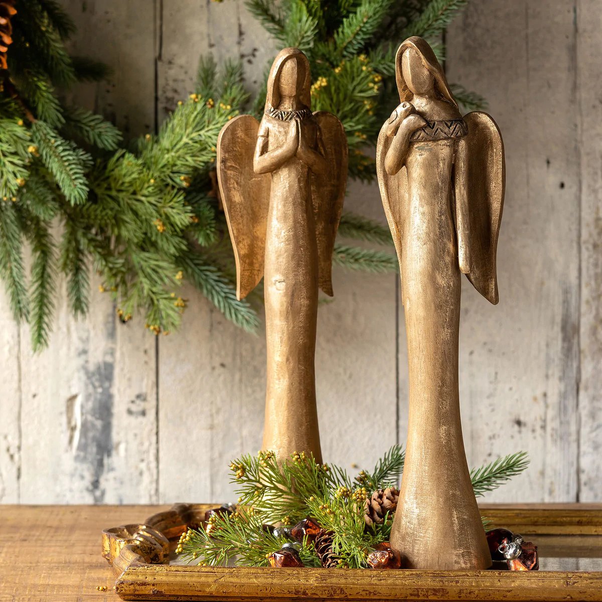 Gold angel sculptures arranged with evergreen Christmas greenery
