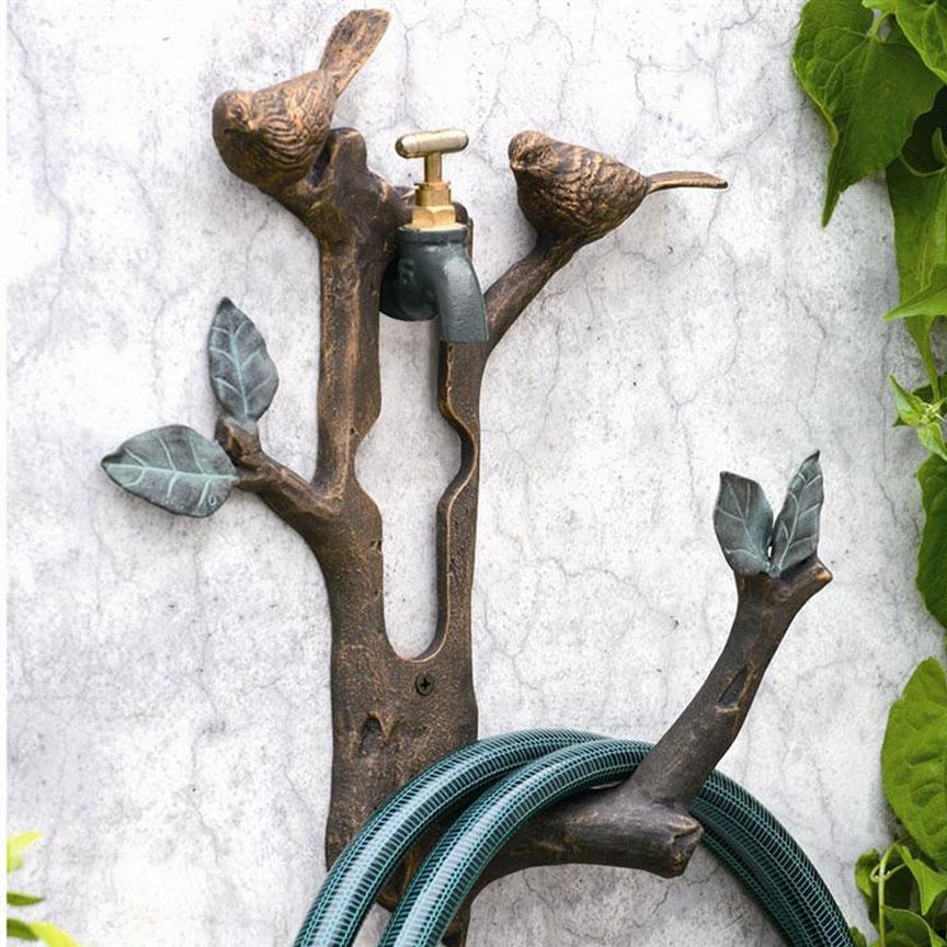 Decorative bird and branch garden hose holder