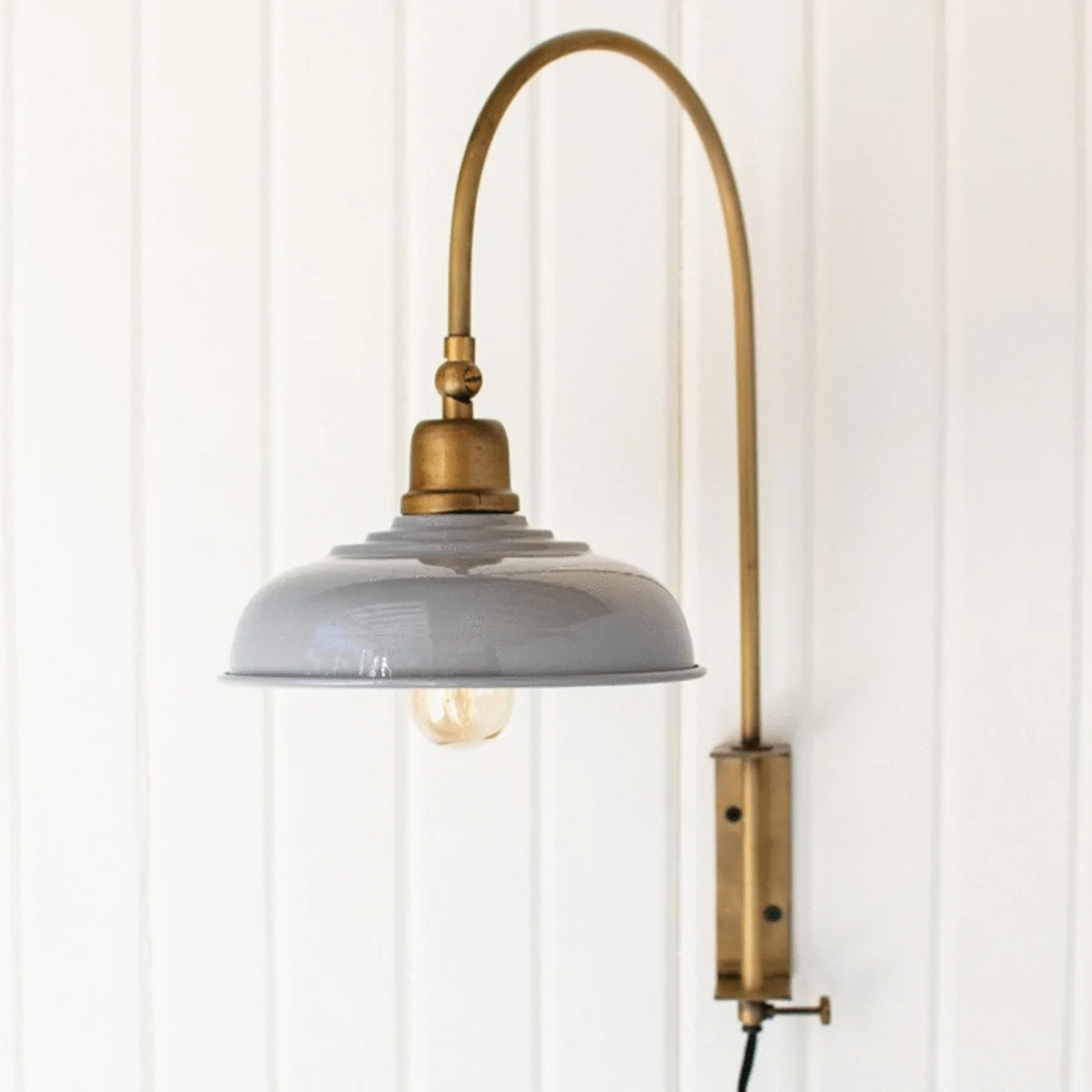 Decorative metal wall sconce with aged brass finish