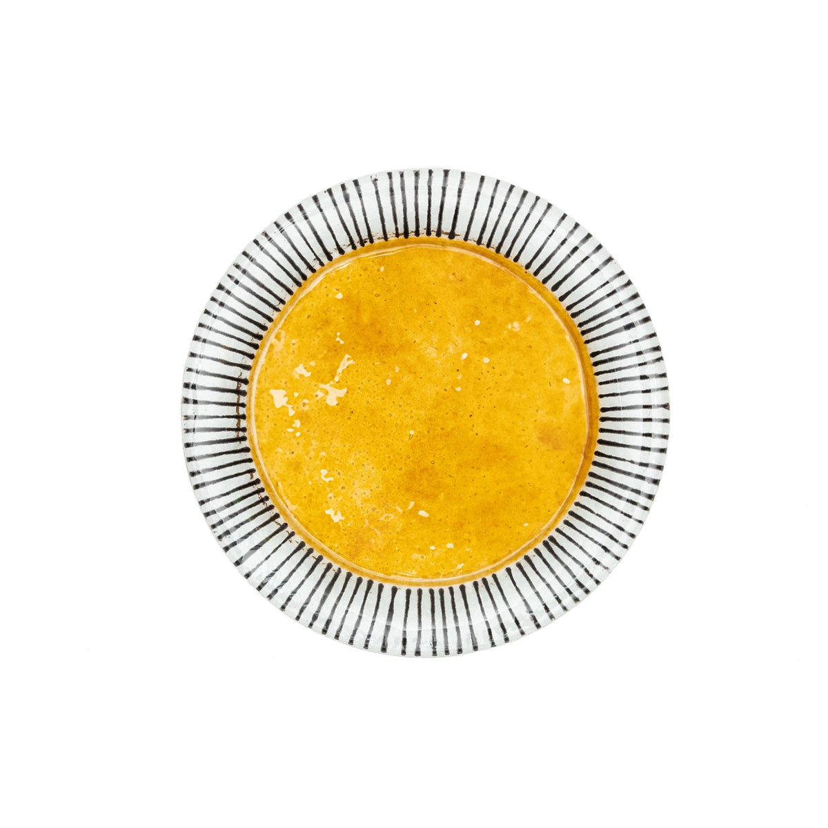 A round glass plate with a bold yellow center and black and white striped rim.