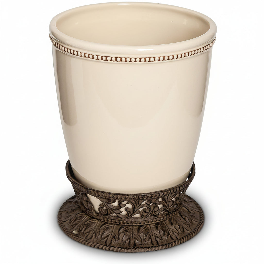 Beige ceramic cup with decorative bronze base on a white background