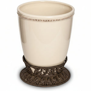 Beige ceramic cup with decorative bronze base on a white background
