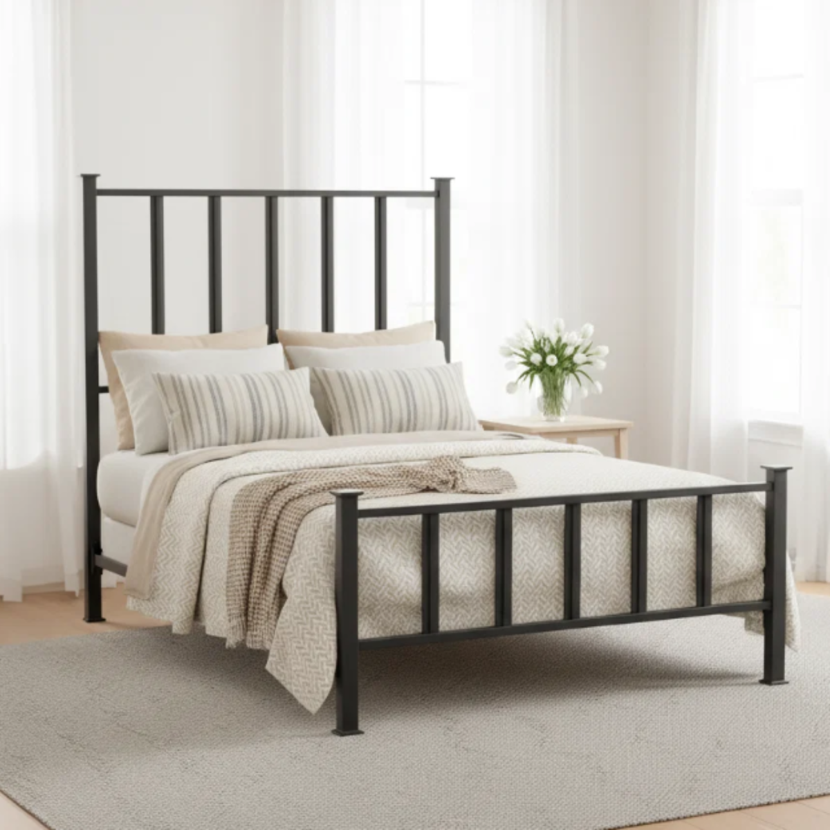 A black metal bed frame with a tall slatted headboard and footboard, styled with neutral beige and white bedding in a bright, modern bedroom.