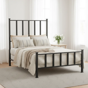 A black metal bed frame with a tall slatted headboard and footboard, styled with neutral beige and white bedding in a bright, modern bedroom.