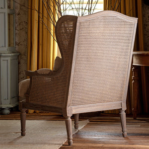 Wicker armchair in a room with curtains and wooden furniture