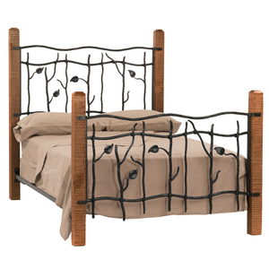 A bed frame with hand-forged ironwork designed to mimic climbing vines with budding leaves, and rugged wooden posts. The bed is made with a beige bedsheet.