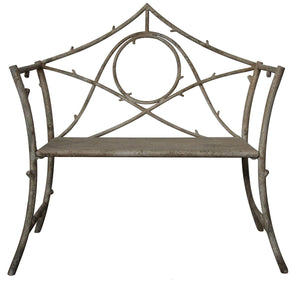 A rustic metal garden bench with a weathered gray-brown finish, featuring a decorative leafy branch backrest and a slatted seat, shown against a plain white background with a product code and dimensions printed below.