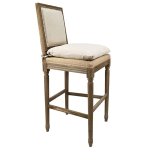 A classic French barstool with a distressed brown wood frame, featuring a cream upholstered backrest and seat cushion with brass nailhead trim, shown on a white background with a model number overlay.