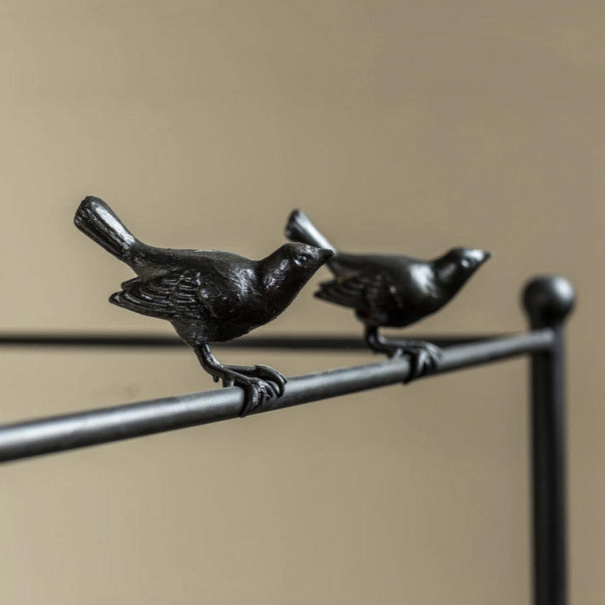 Black metal canopy bed with white bedding on a wooden floor.