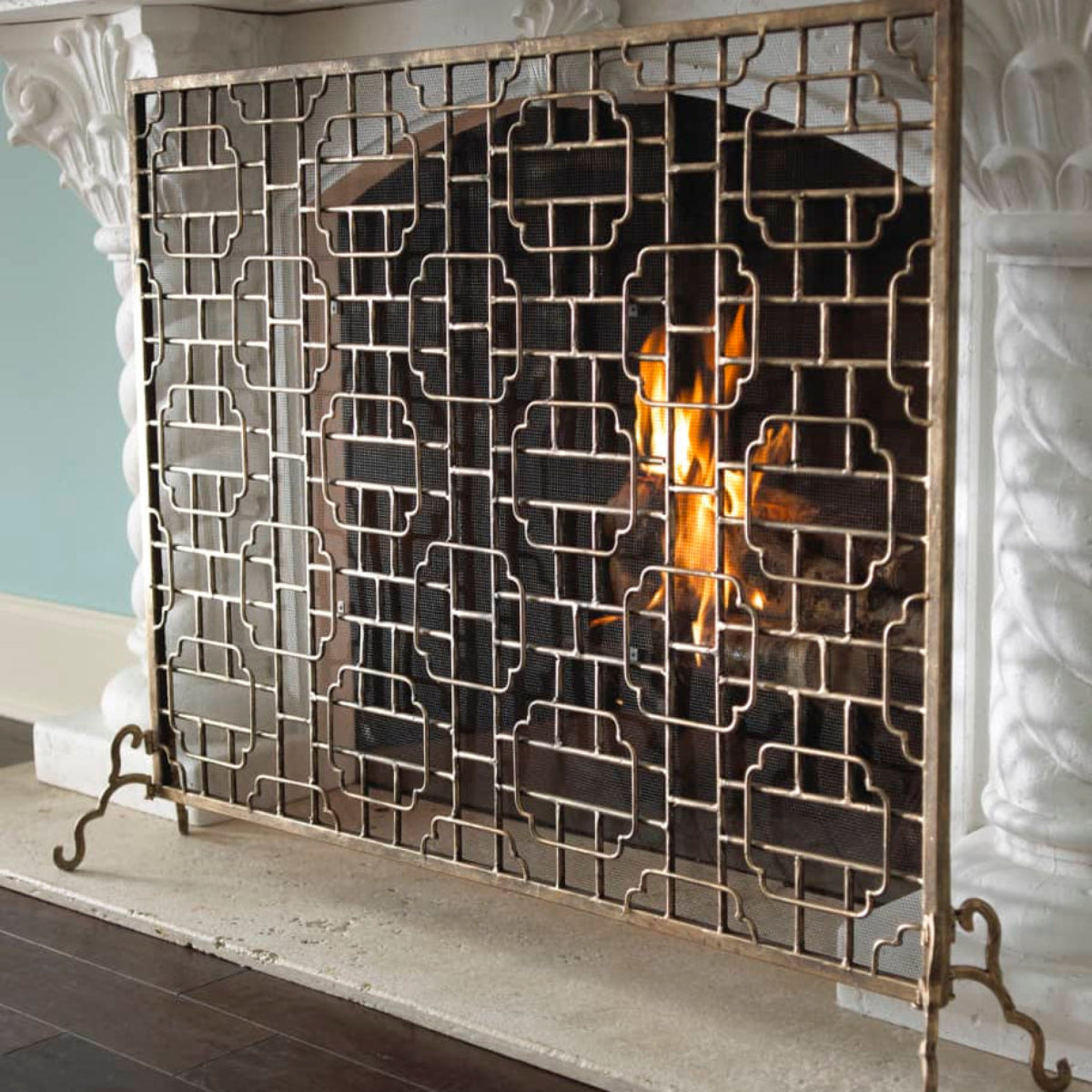 Decorative metal screen with intricate lattice design on a white background