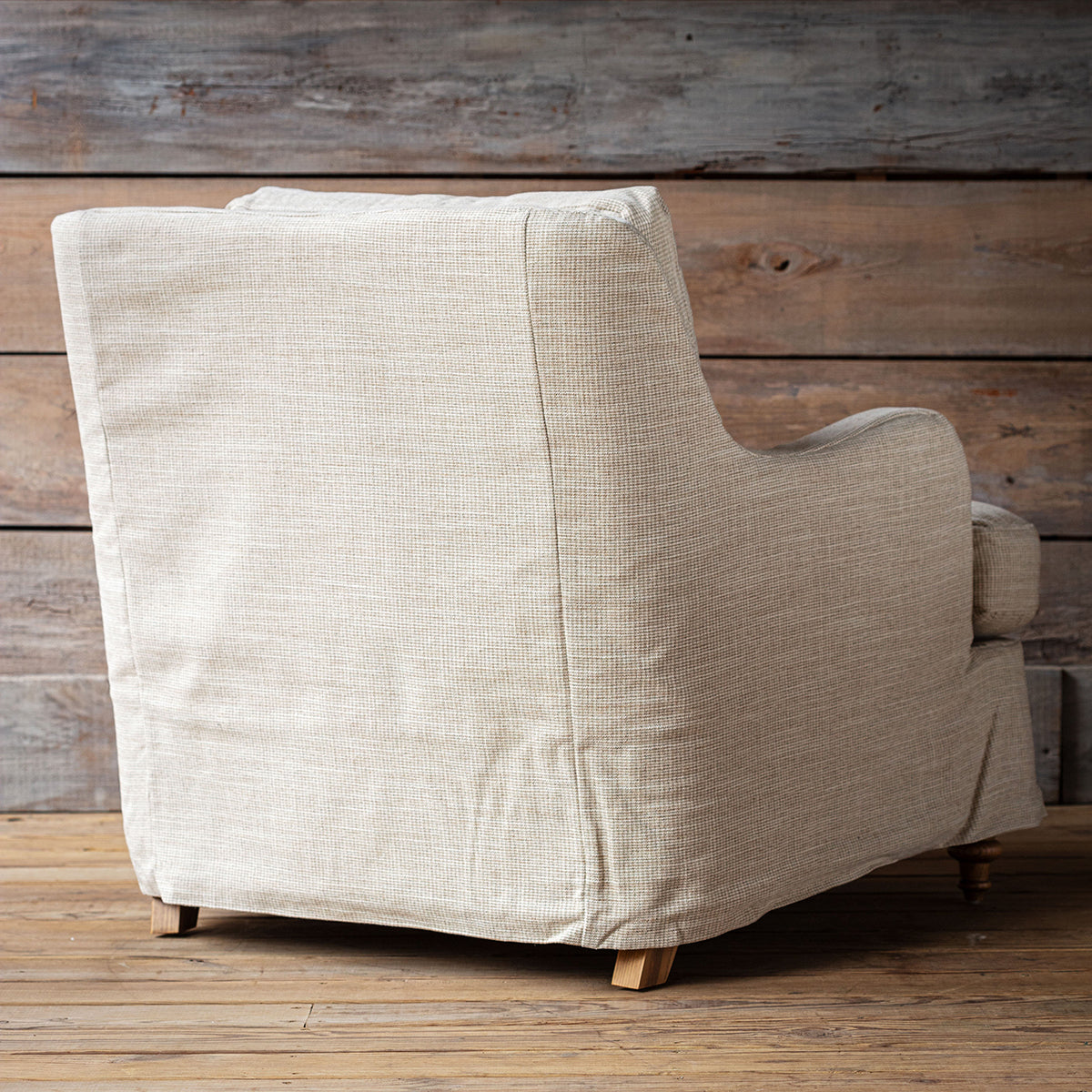 Beige armchair against a wooden wall