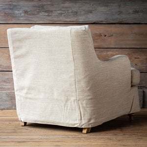 Beige armchair against a wooden wall