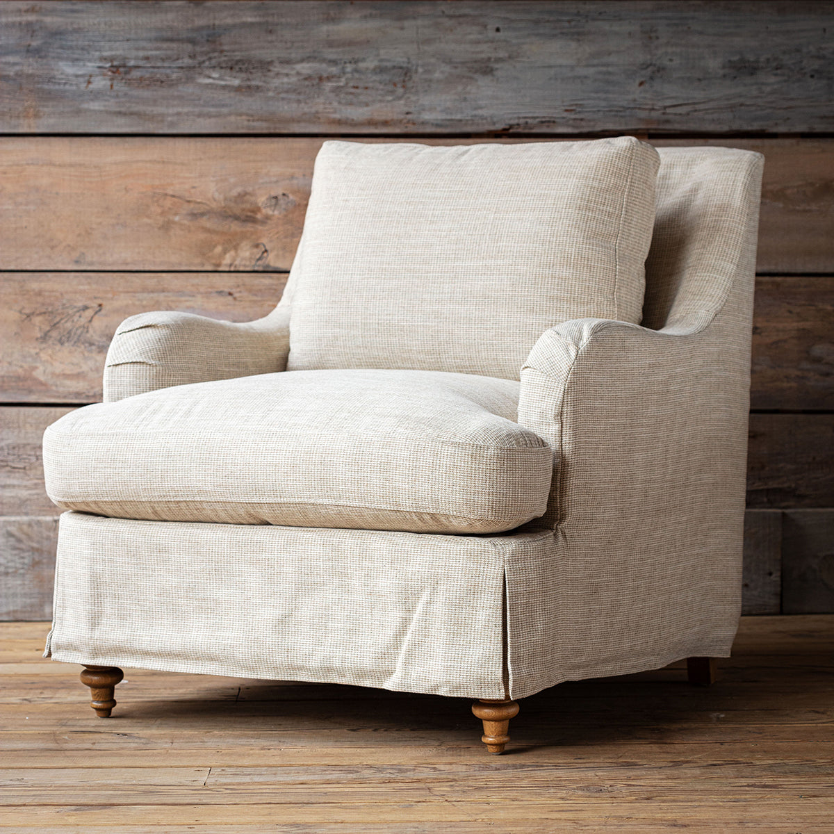 Beige armchair against a wooden wall