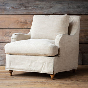 Beige armchair against a wooden wall