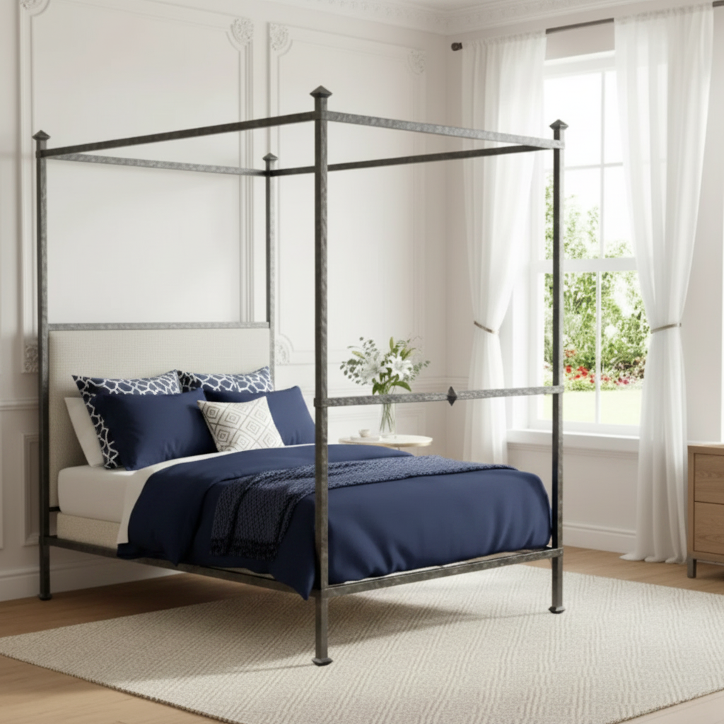 A four-poster canopy bed with a dark metal frame and upholstered headboard, styled with cream bedding in a bright, classic bedroom.