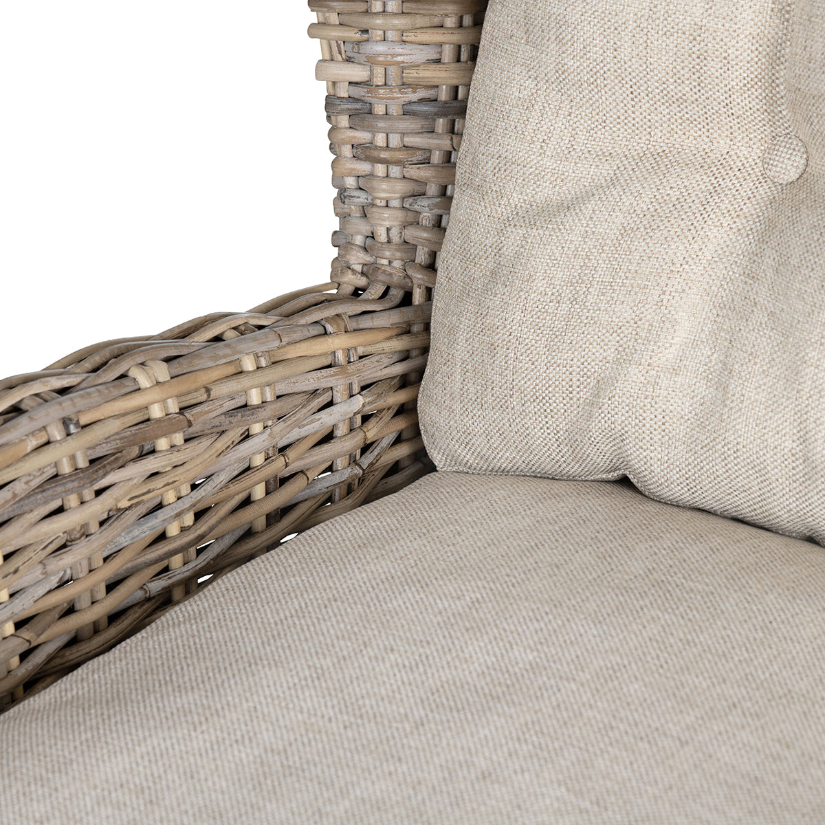 Close-up of a woven wicker or rattan chair arm and seat cushion in a light beige fabric, with part of a matching back cushion visible against a white background.
