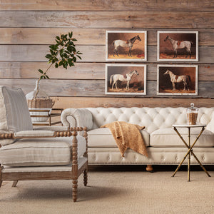Living room with a white sofa, armchair, and horse-themed wall art.