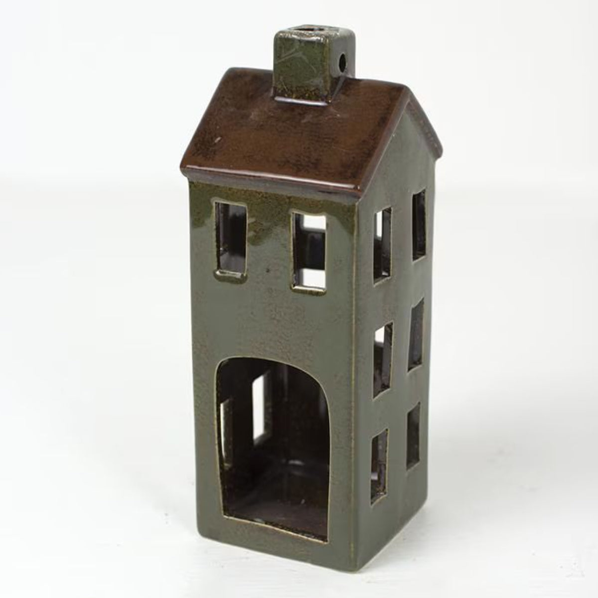 Colorful ceramic Christmas village church and houses on a wood shelf
