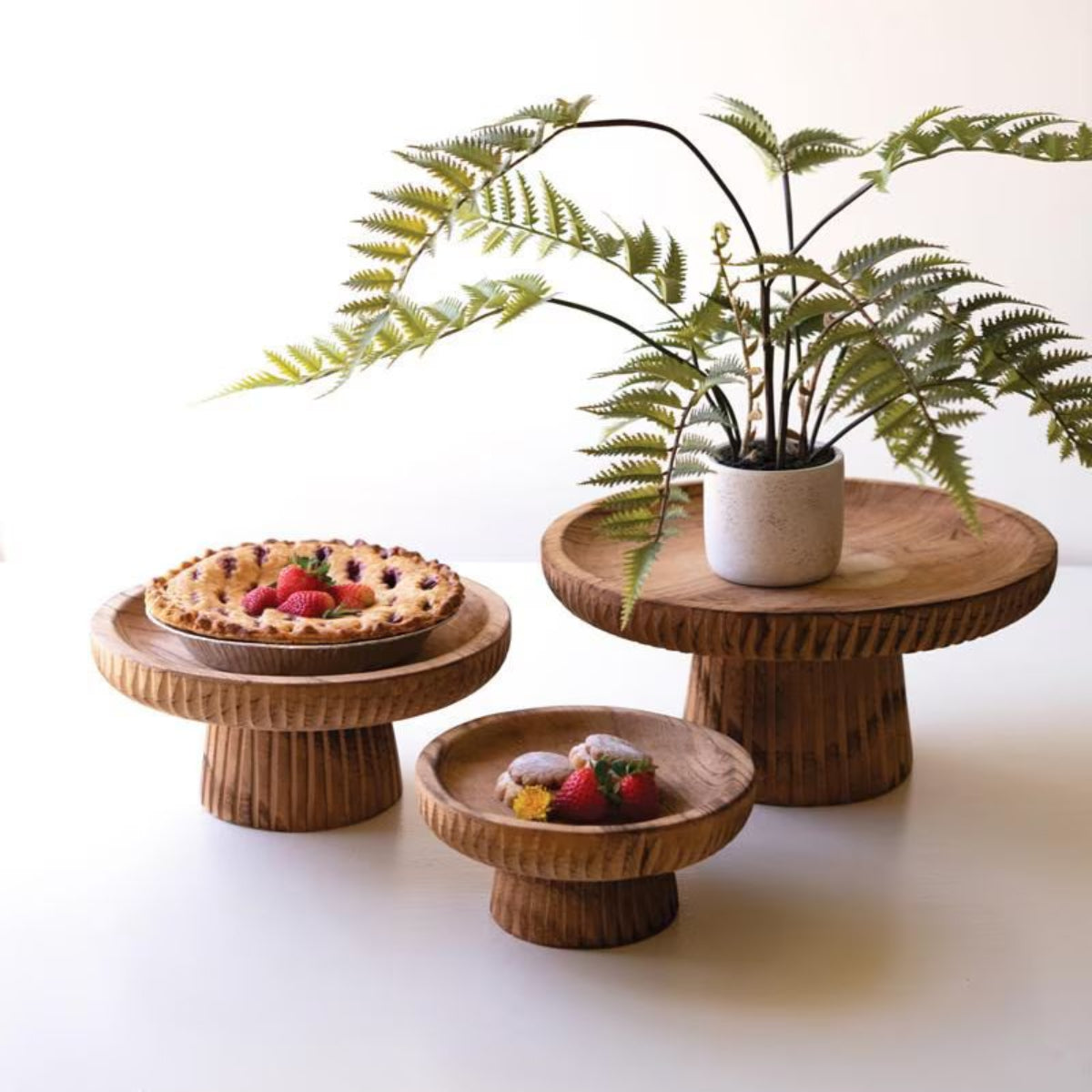 Etched wood serving stands set of 3 styled with a fern and fruit