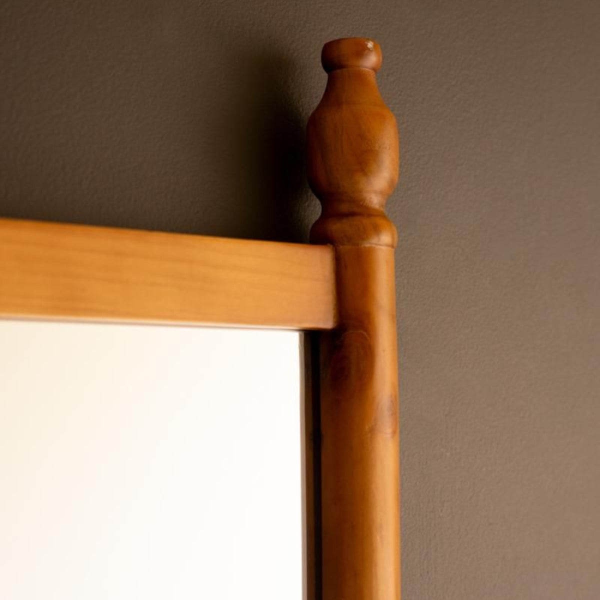 Close-up of turned wood finial on mirror frame