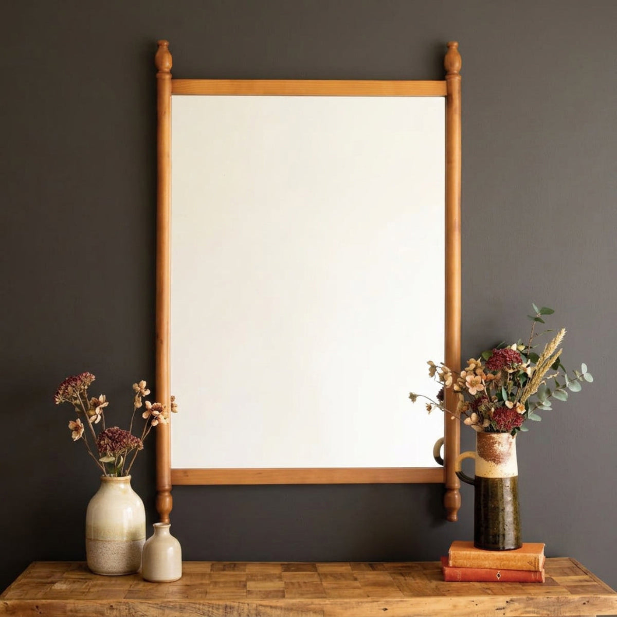 Finial Wood Frame Wall Mirror hung above a console on a dark wall