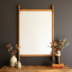 Finial Wood Frame Wall Mirror hung above a console on a dark wall
