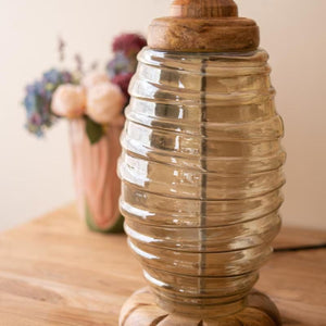 Detail of glass lamp base and wood foot with flowers