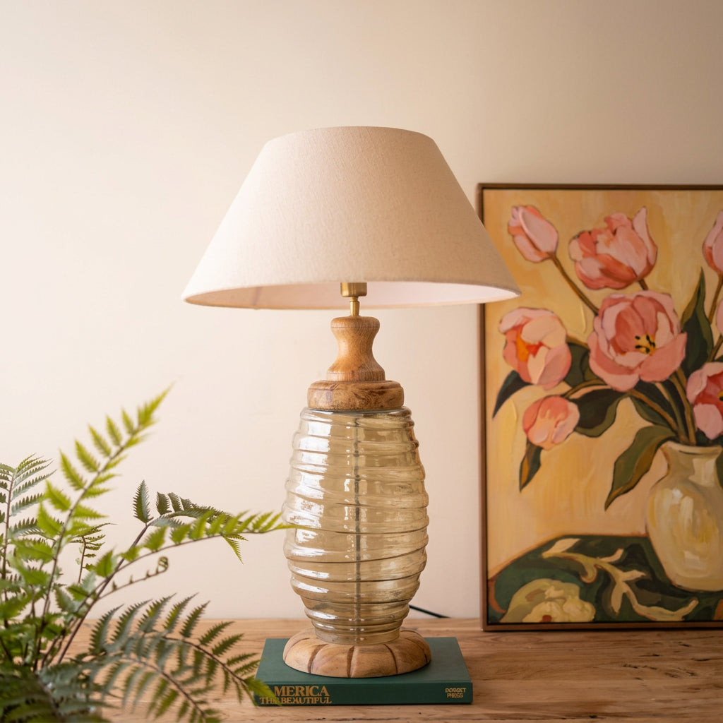 Glass and wood table lamp with fabric shade styled on a table