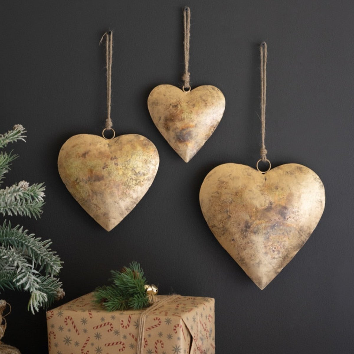 Three distressed gold metal hearts on jute hangers