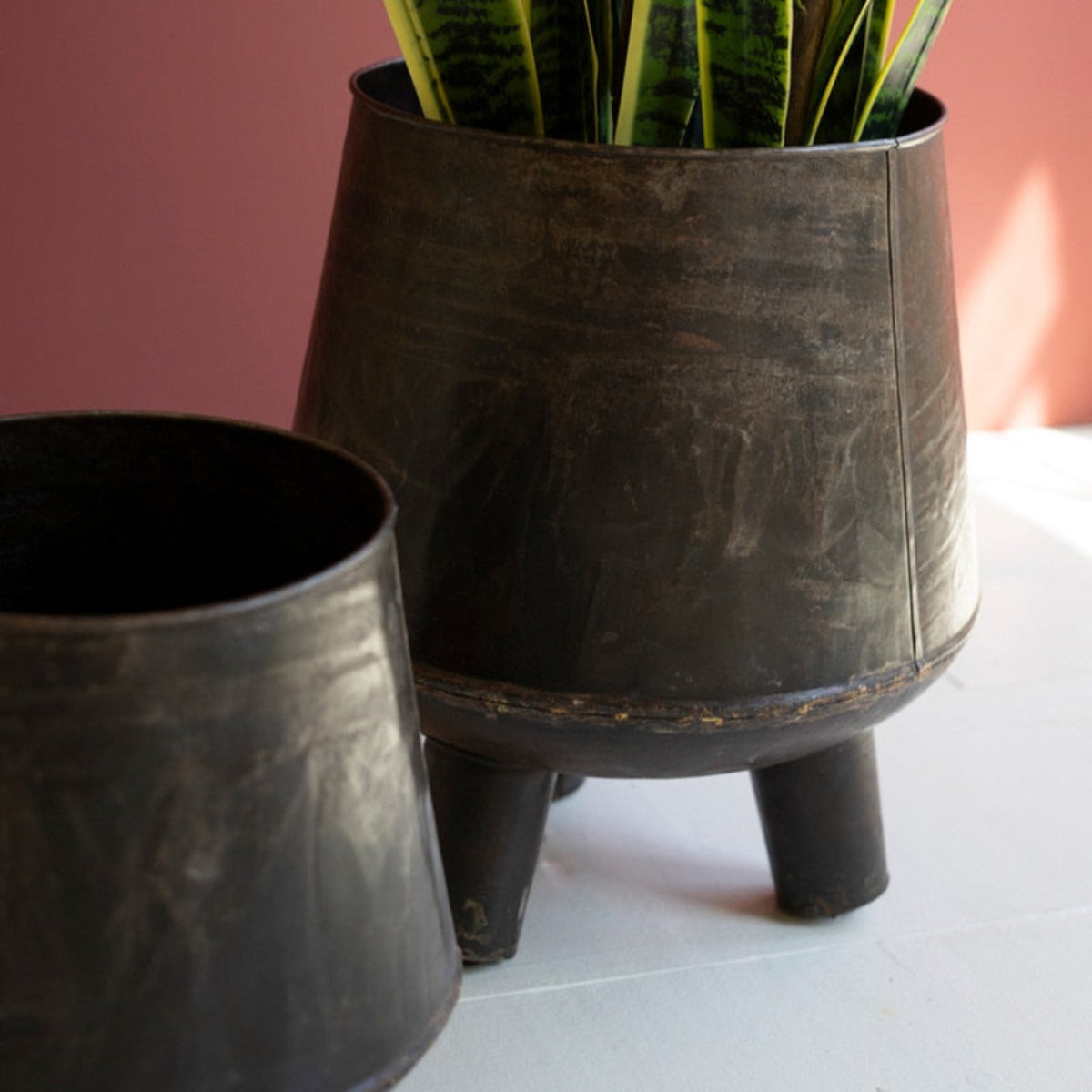 Two hand-hammered iron planters on legs