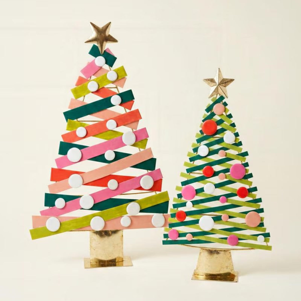 Striped metal Christmas trees styled with a red sleigh and wrapped gifts