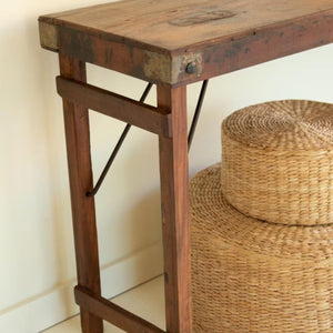 Reclaimed wood folding console table styled with a basket and plant