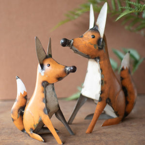 Two distressed orange recycled metal fox figurines