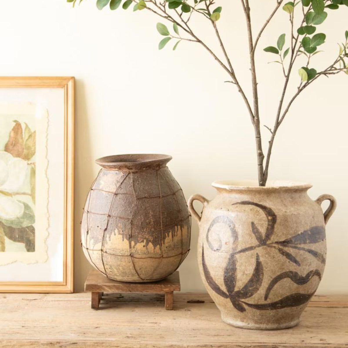 Rustic ceramic vessel grouped with pottery and branches