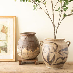 Rustic ceramic vessel grouped with pottery and branches