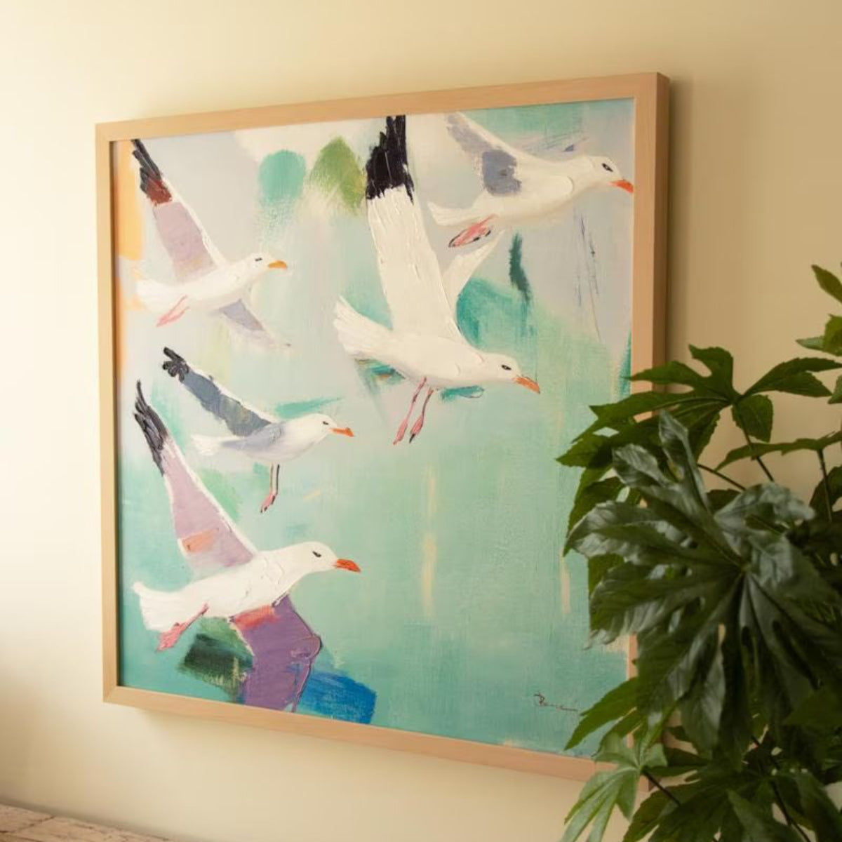 Angled view of framed seagull canvas with greenery