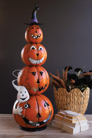 Stacked painted metal jack-o-lanterns with witch hat in a fall display with books and basket