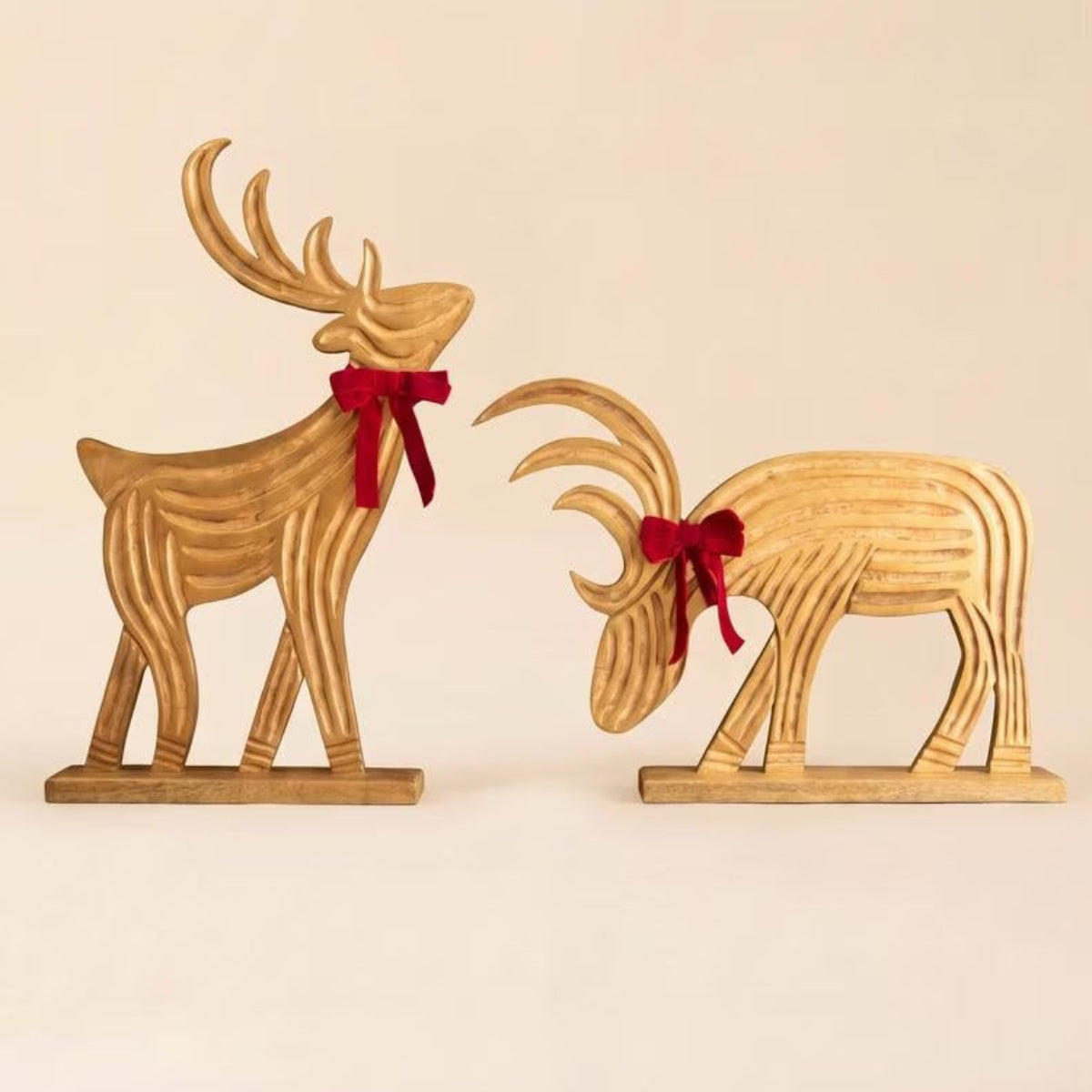 Standing and grazing carved mango wood reindeer on a white background