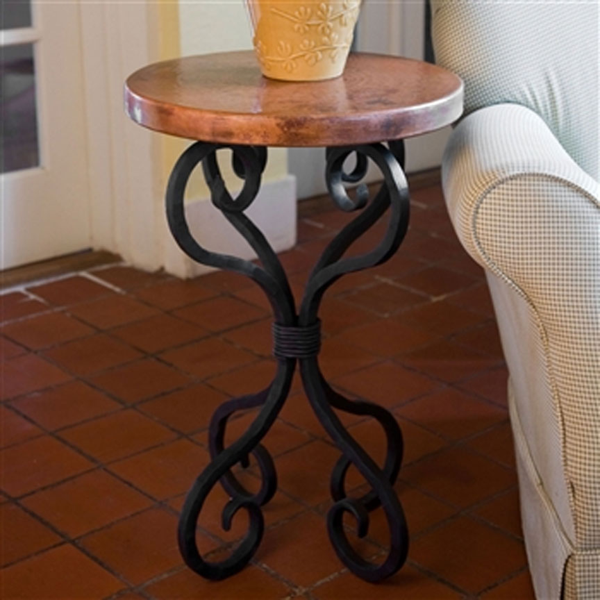 Scrollwork iron table base paired with a warm round wood tabletop